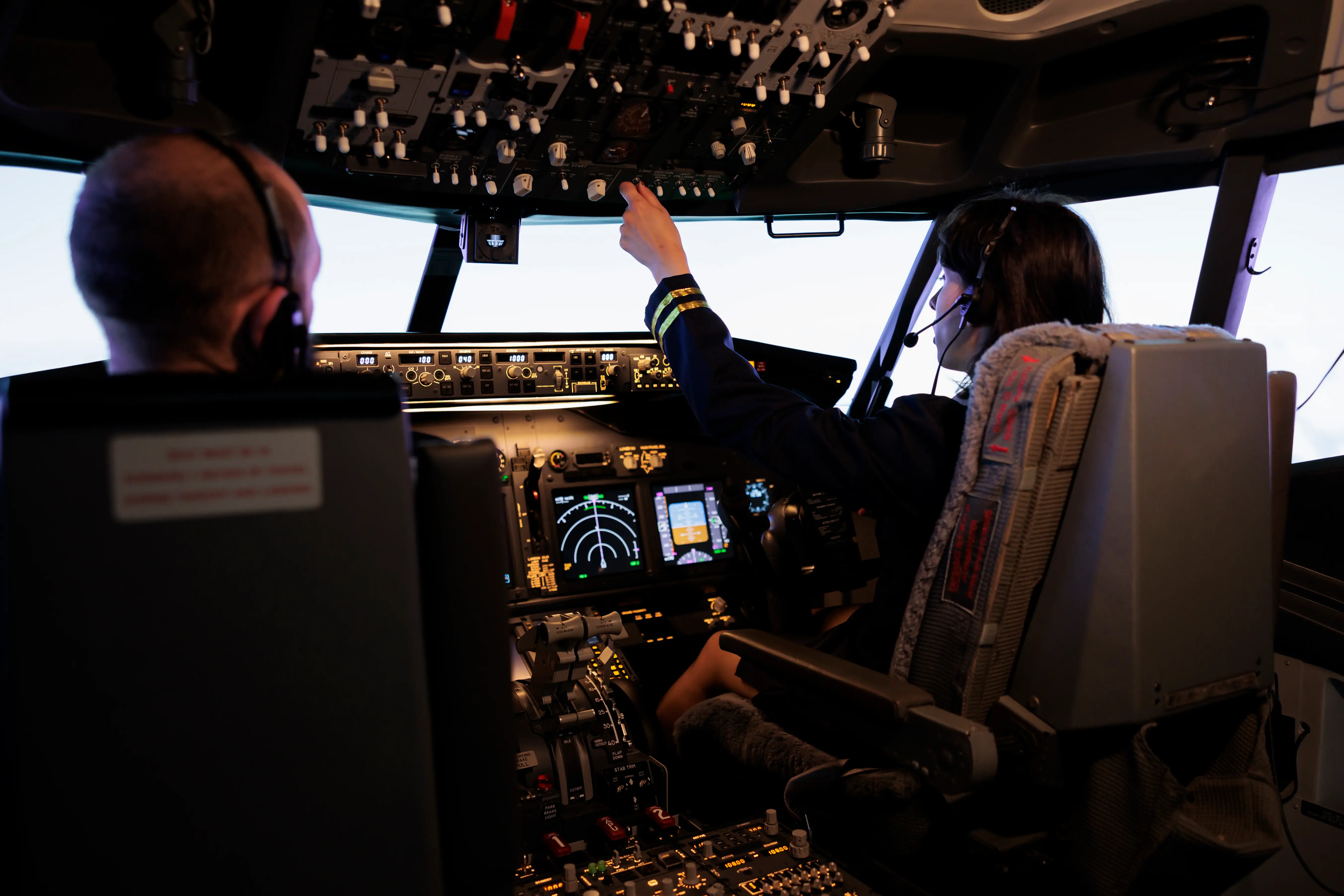 Female pilot assisting captain during takeoff