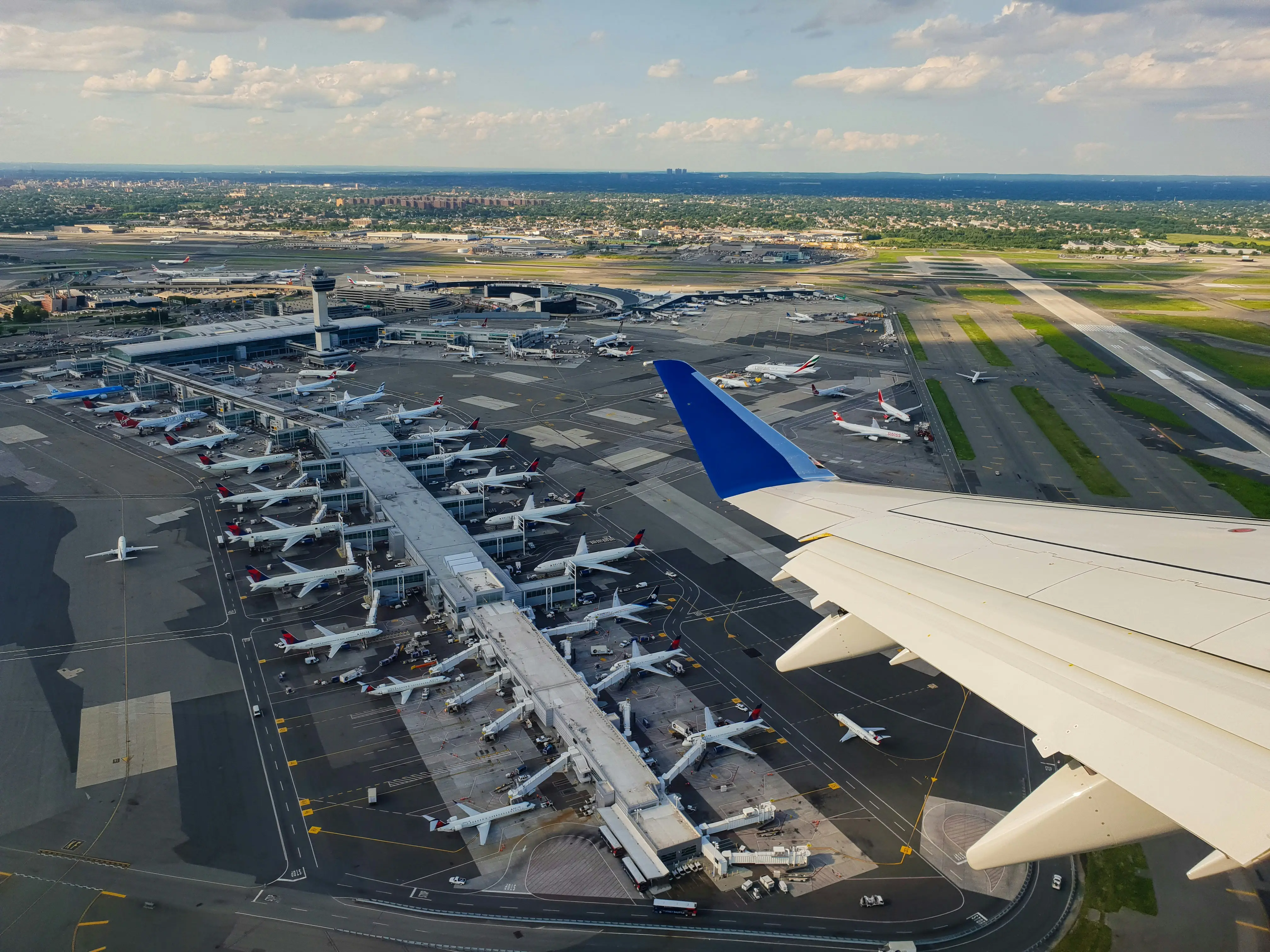 View from a commercial airplane wing over a busy airport, representing a pilot's career
